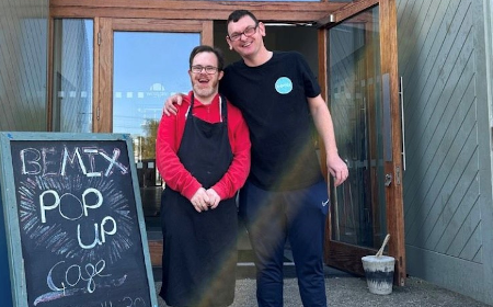Two people standing next to a sign that reads "Bemix pop up"